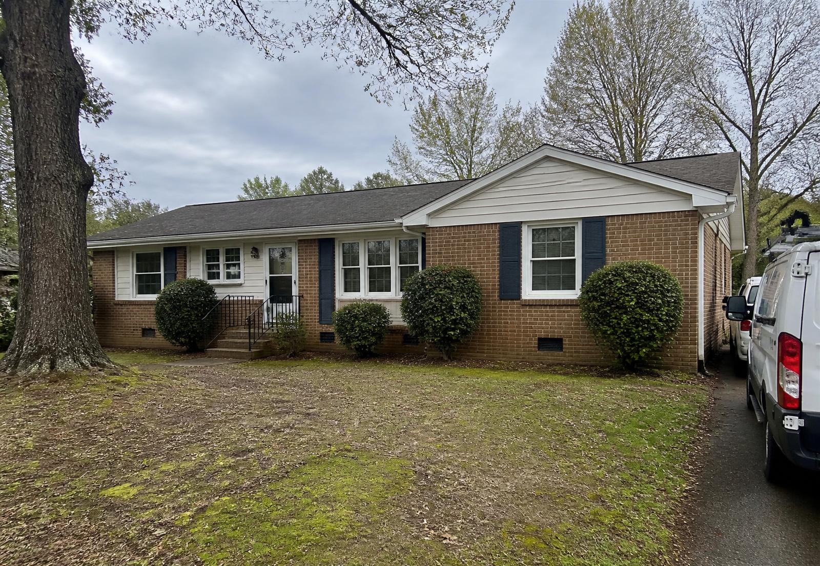 Brick ranch home in a North Carolina neighborhood with a work van in the driveway